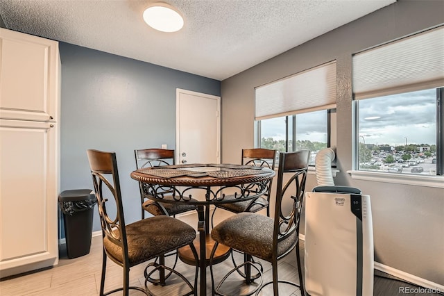 8100 W Quincy Ave Unit 11, Denver, CO 80123 - dining room with a textured ceiling, light wood-type flooring, and baseboards