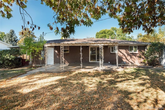 back of house with a lawn and a patio area