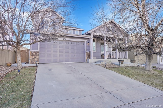 view of front of property featuring a garage, a front yard, and covered porch