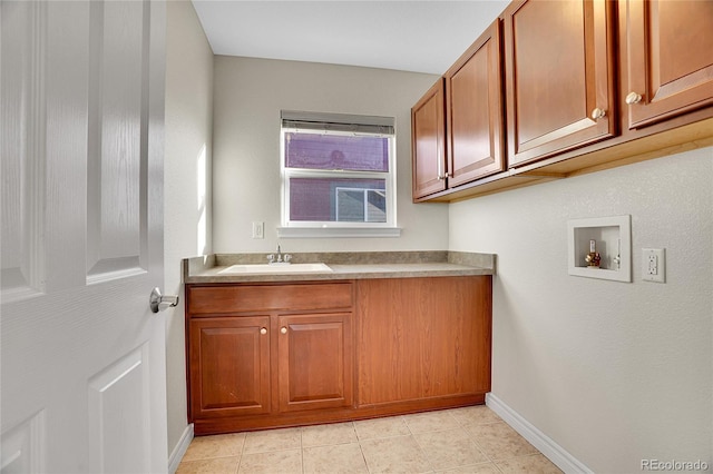 laundry area with light tile patterned flooring, cabinets, washer hookup, and sink