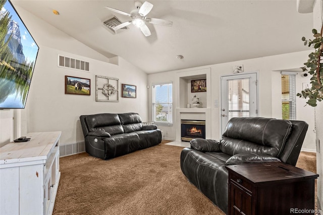 carpeted living room with ceiling fan and vaulted ceiling