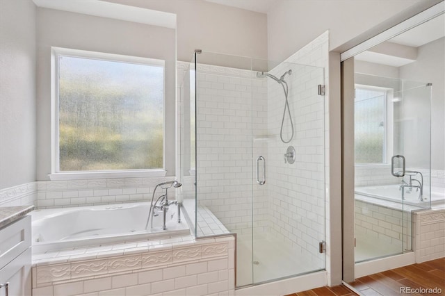 bathroom with vanity, wood-type flooring, and independent shower and bath