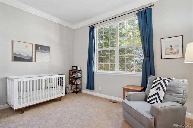 carpeted bedroom featuring crown molding and a nursery area