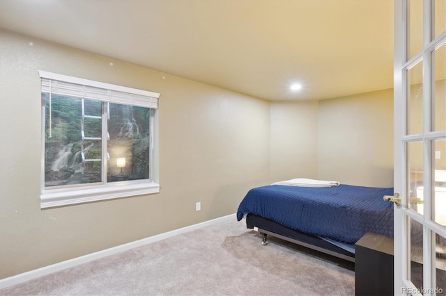 bedroom featuring light carpet and multiple windows