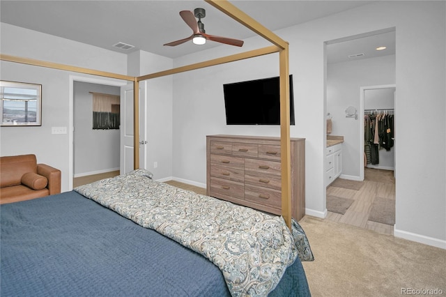 carpeted bedroom with ceiling fan, a closet, and a walk in closet