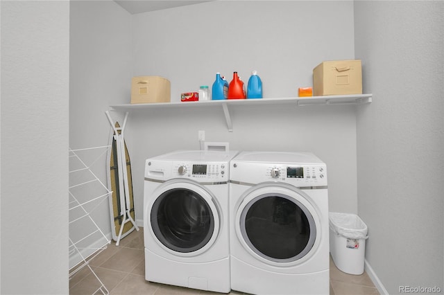 laundry area with light tile patterned floors and washing machine and clothes dryer