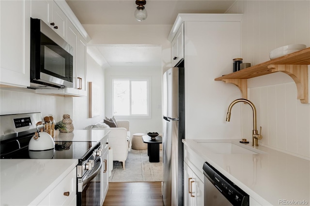 kitchen featuring white cabinets, appliances with stainless steel finishes, dark hardwood / wood-style flooring, and sink