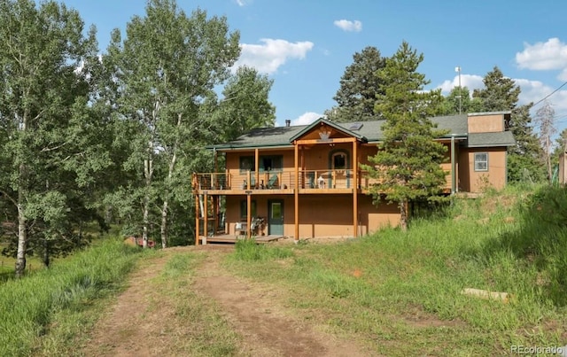 20033 Silver Ranch Rd, Conifer, CO 80433 - rear view of property featuring a wooden deck, driveway, and stucco siding