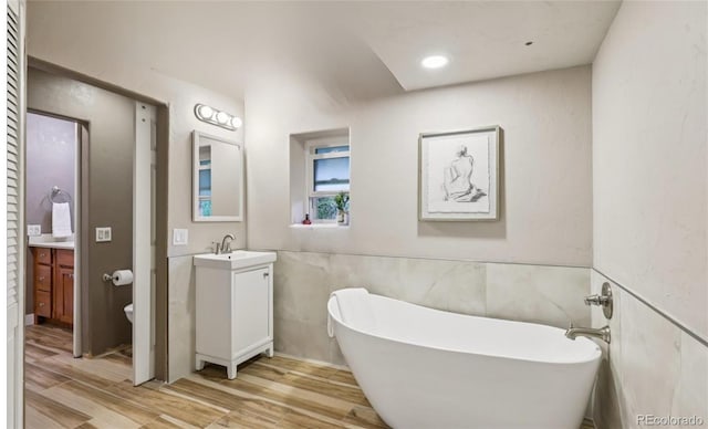 20033 Silver Ranch Rd, Conifer, CO 80433 - full bathroom with vanity, a soaking tub, wood finished floors, and tile walls