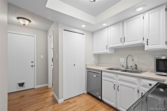 kitchen with appliances with stainless steel finishes, a sink, white cabinetry, light wood finished floors, and recessed lighting