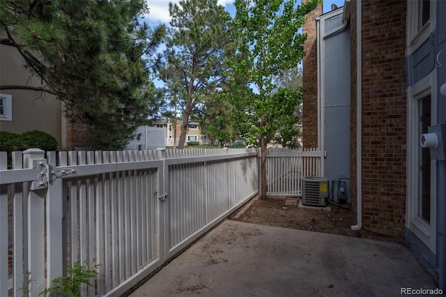 view of patio / terrace featuring cooling unit, fence, and a gate