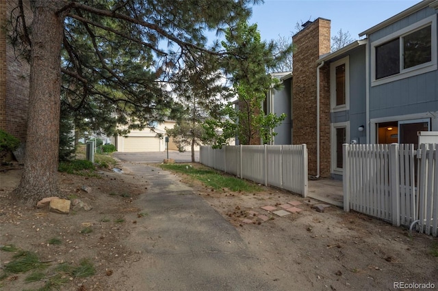 view of side of home with a chimney and fence