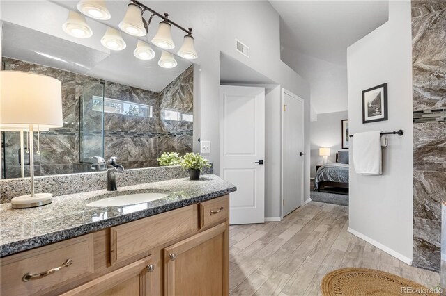 bathroom with visible vents, ensuite bathroom, vanity, wood finished floors, and a walk in shower