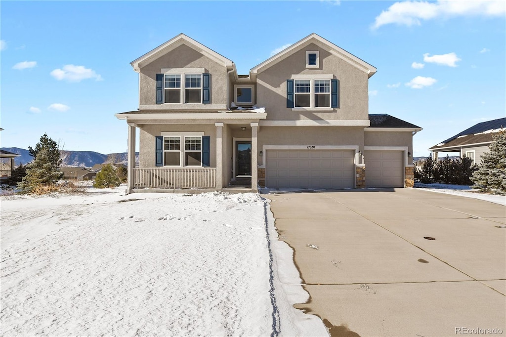 view of front of house featuring a mountain view, a porch, and a garage