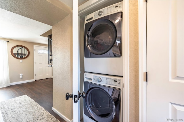 315 Maestes St, Johnstown, CO 80534 - clothes washing area featuring baseboards, laundry area, dark wood finished floors, and stacked washer / dryer