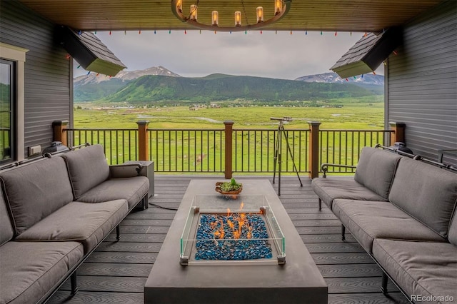 wooden deck featuring outdoor lounge area, a mountain view, and a rural view