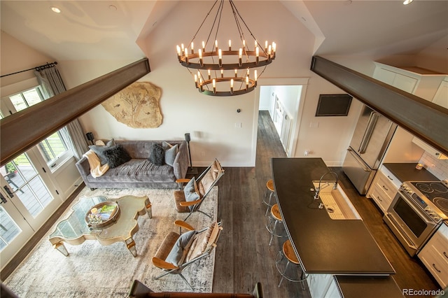 living room featuring dark hardwood / wood-style floors, lofted ceiling, and a chandelier