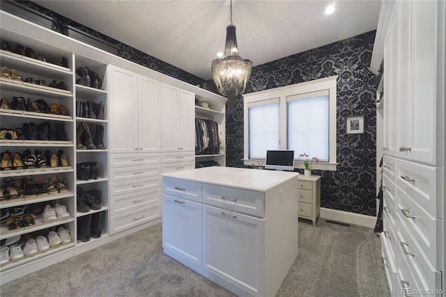 walk in closet featuring carpet floors and a notable chandelier