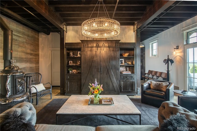 living room featuring beamed ceiling, an inviting chandelier, and wood walls