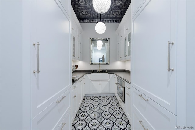 921 County Road 317, Crested Butte, CO 81224 - kitchen featuring a sink, stainless steel oven, white cabinets, glass insert cabinets, and dark countertops