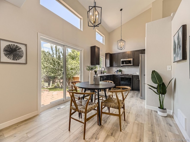4287 Brookwood Pl, Highlands Ranch, CO 80130 - dining space featuring a chandelier, light wood-type flooring, and high vaulted ceiling