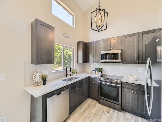 4287 Brookwood Pl, Highlands Ranch, CO 80130 - kitchen featuring stainless steel appliances, light countertops, decorative backsplash, a towering ceiling, and light wood finished floors