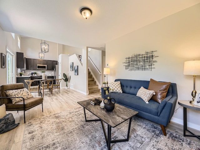 4287 Brookwood Pl, Highlands Ranch, CO 80130 - living room featuring stairway, light wood-style flooring, and a chandelier