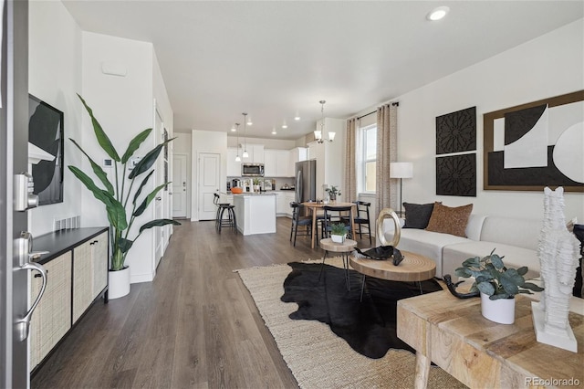 living room featuring a chandelier and dark hardwood / wood-style floors