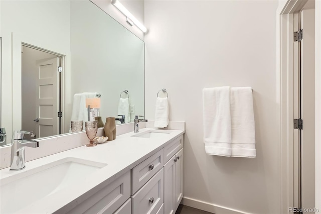 bathroom featuring double vanity and baseboards