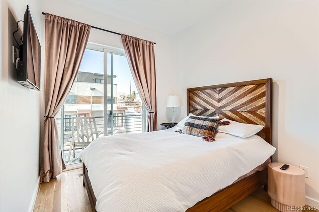 bedroom with access to exterior, wood finished floors, and baseboards