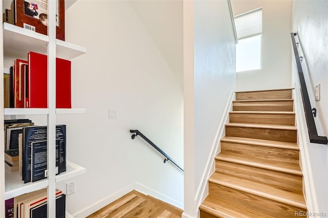 stairs with wood finished floors and baseboards