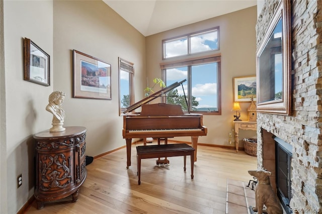 sitting room with baseboards, a fireplace, and light wood finished floors