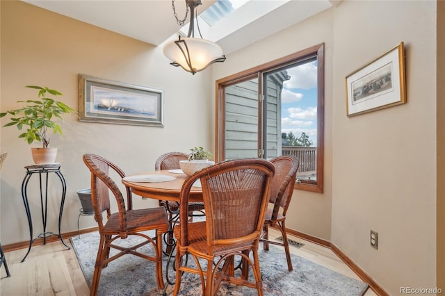 dining area with baseboards and light wood finished floors
