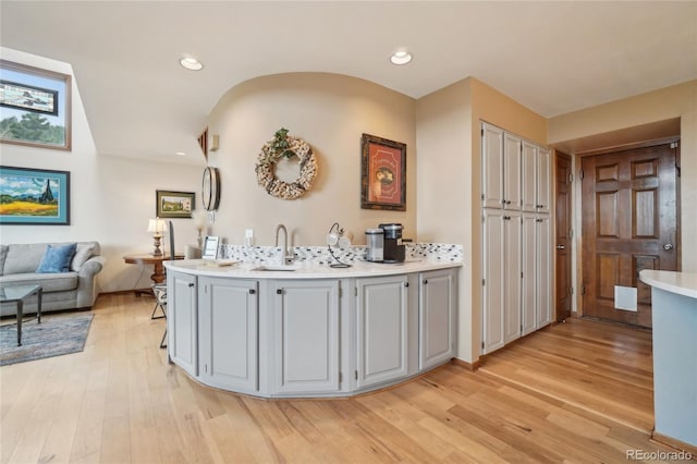 interior space featuring a sink, light wood finished floors, light countertops, recessed lighting, and gray cabinetry