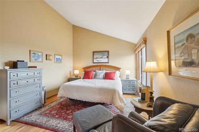 bedroom featuring light wood finished floors and vaulted ceiling