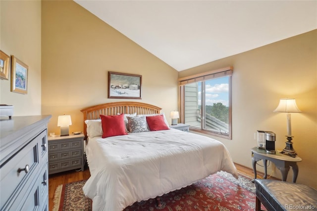 bedroom with vaulted ceiling and wood finished floors
