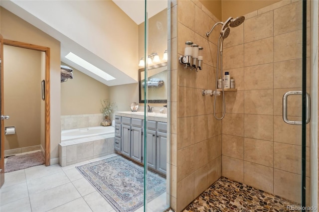 full bath with tile patterned flooring, vanity, a garden tub, vaulted ceiling with skylight, and a shower stall