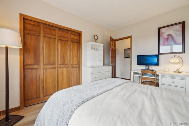 bedroom featuring baseboards, light wood-style flooring, and a closet
