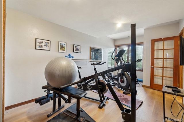exercise area featuring baseboards and light wood-style flooring