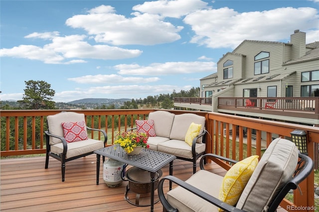 deck featuring a mountain view and an outdoor living space