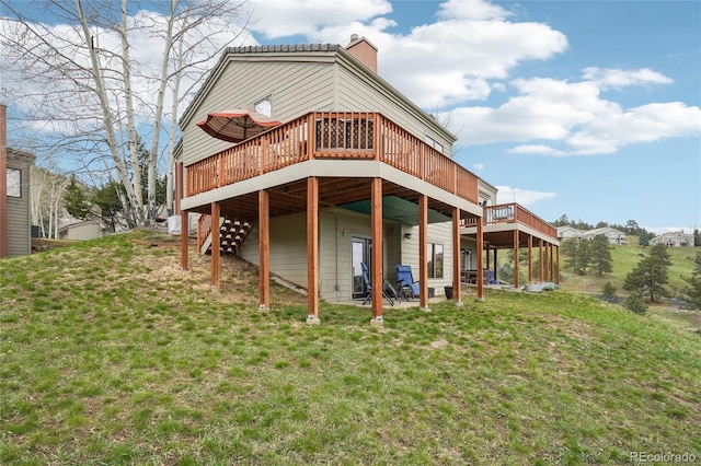 rear view of house featuring a chimney, stairway, a yard, and a deck