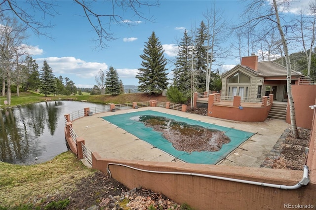 view of pool with a deck with water view and a fenced in pool