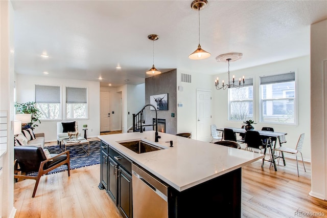kitchen with visible vents, a chandelier, dark cabinets, a sink, and dishwasher