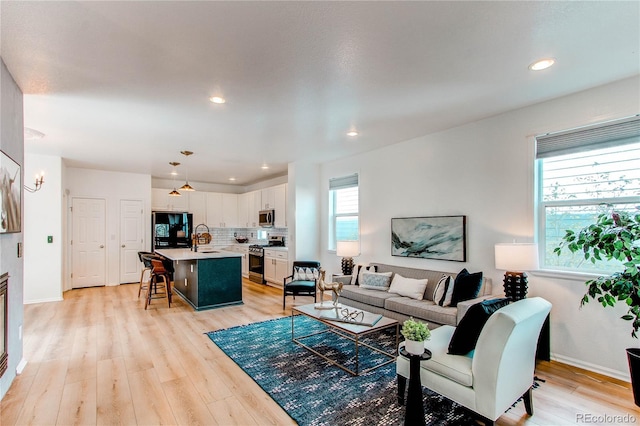living room featuring light wood-style floors, recessed lighting, and baseboards