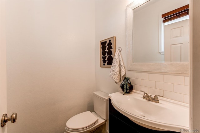 bathroom with vanity, decorative backsplash, and toilet