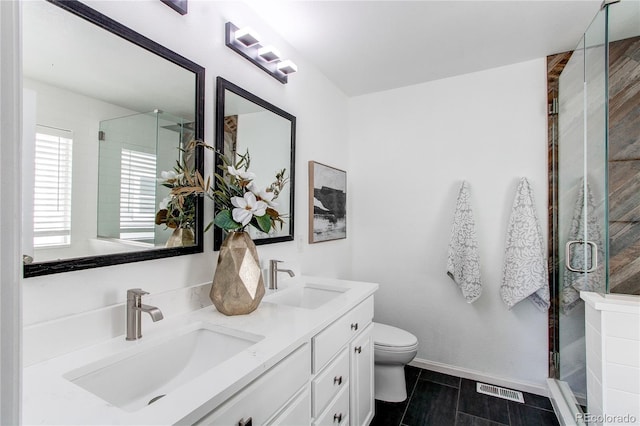 full bath featuring a sink, a shower stall, toilet, and visible vents