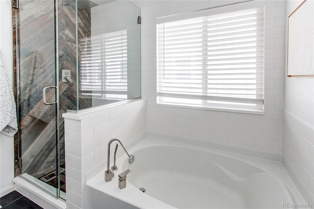 full bath with a shower stall and a garden tub