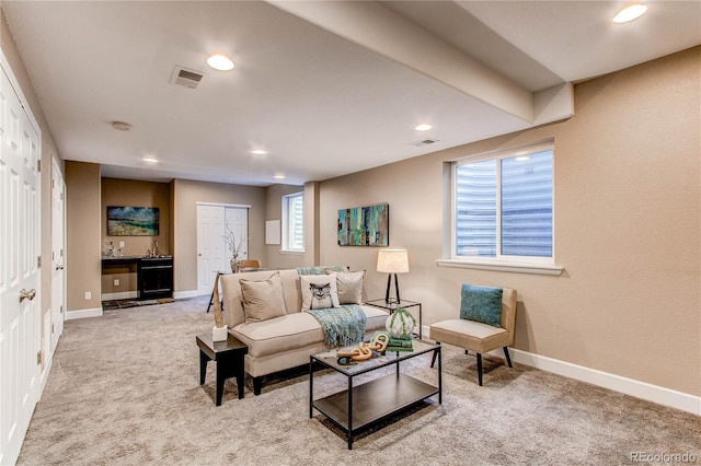 living area featuring visible vents, baseboards, indoor wet bar, carpet flooring, and recessed lighting