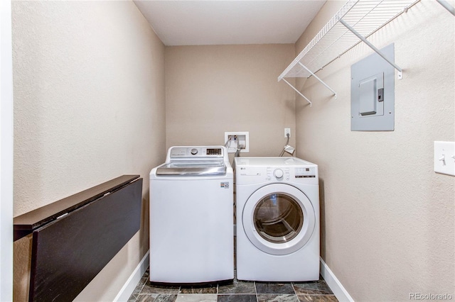 laundry room featuring baseboards, electric panel, washer and clothes dryer, and laundry area