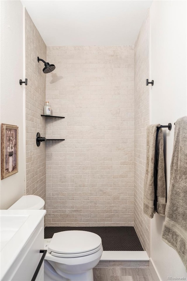 full bath featuring vanity, a shower stall, toilet, and wood finished floors